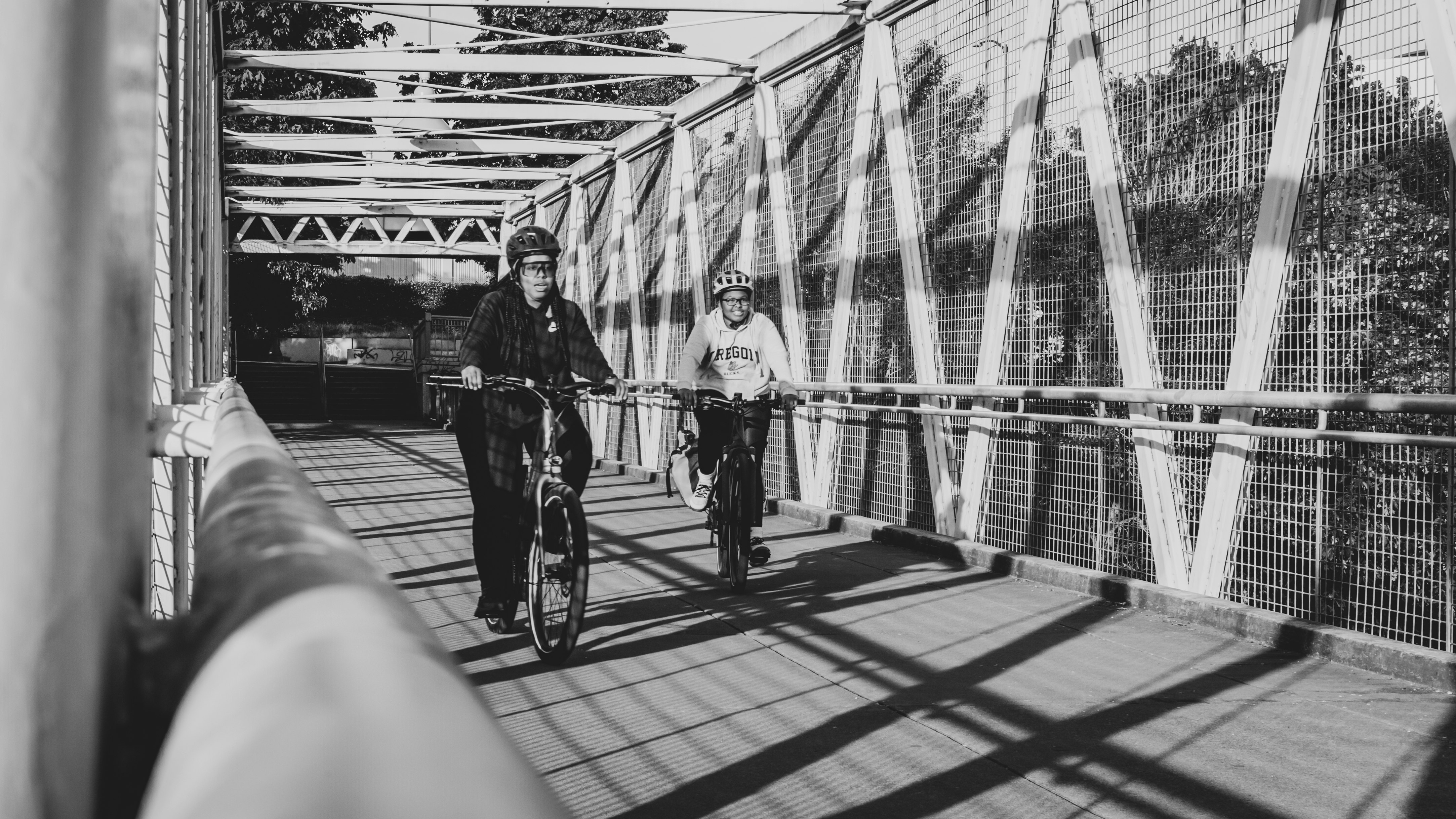 grayscale photo of man and woman riding bicycle